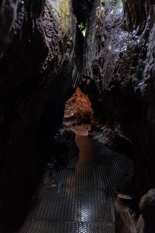 濡れた通路をたどる入水鍾乳洞の洞内の写真