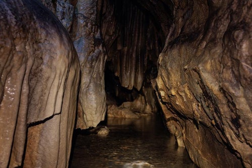 入水鍾乳洞の洞内暗がりと地下水の写真