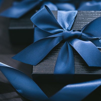 青いリボンで封がされたプレゼントの写真