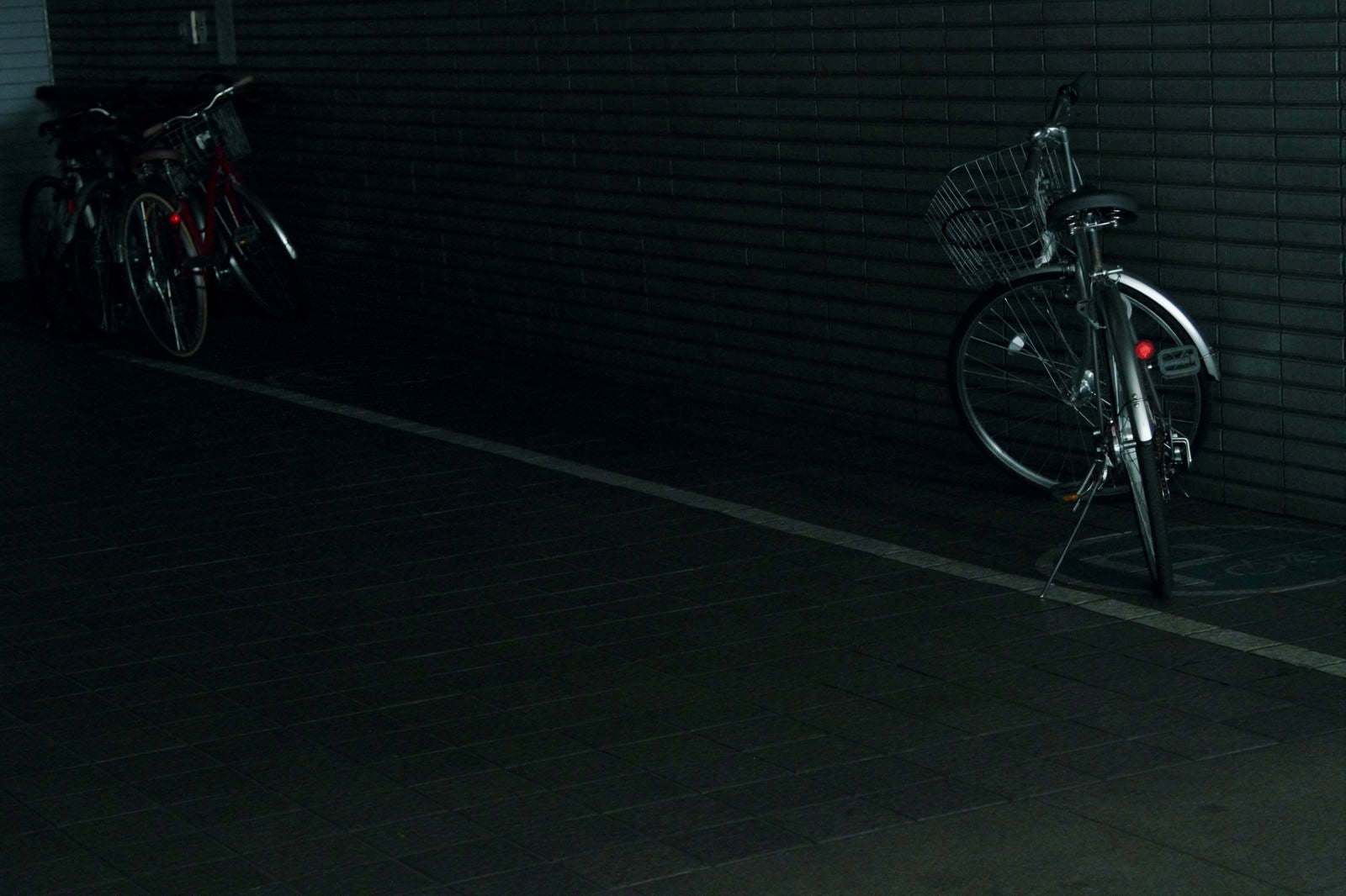 「暗い駐輪場の自転車」の写真