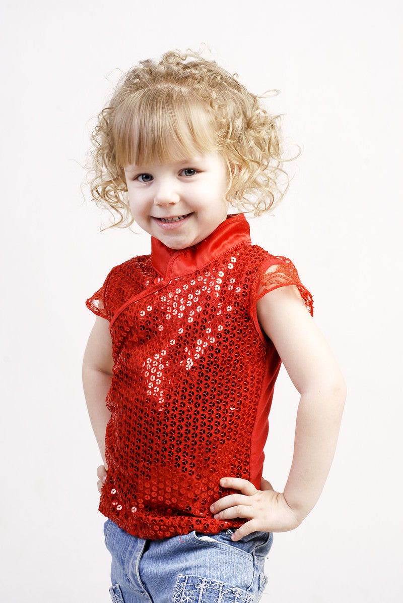 「90年代ぽい赤い服を着たブロンドヘアの女の子」の写真［モデル：モデルファクトリー］