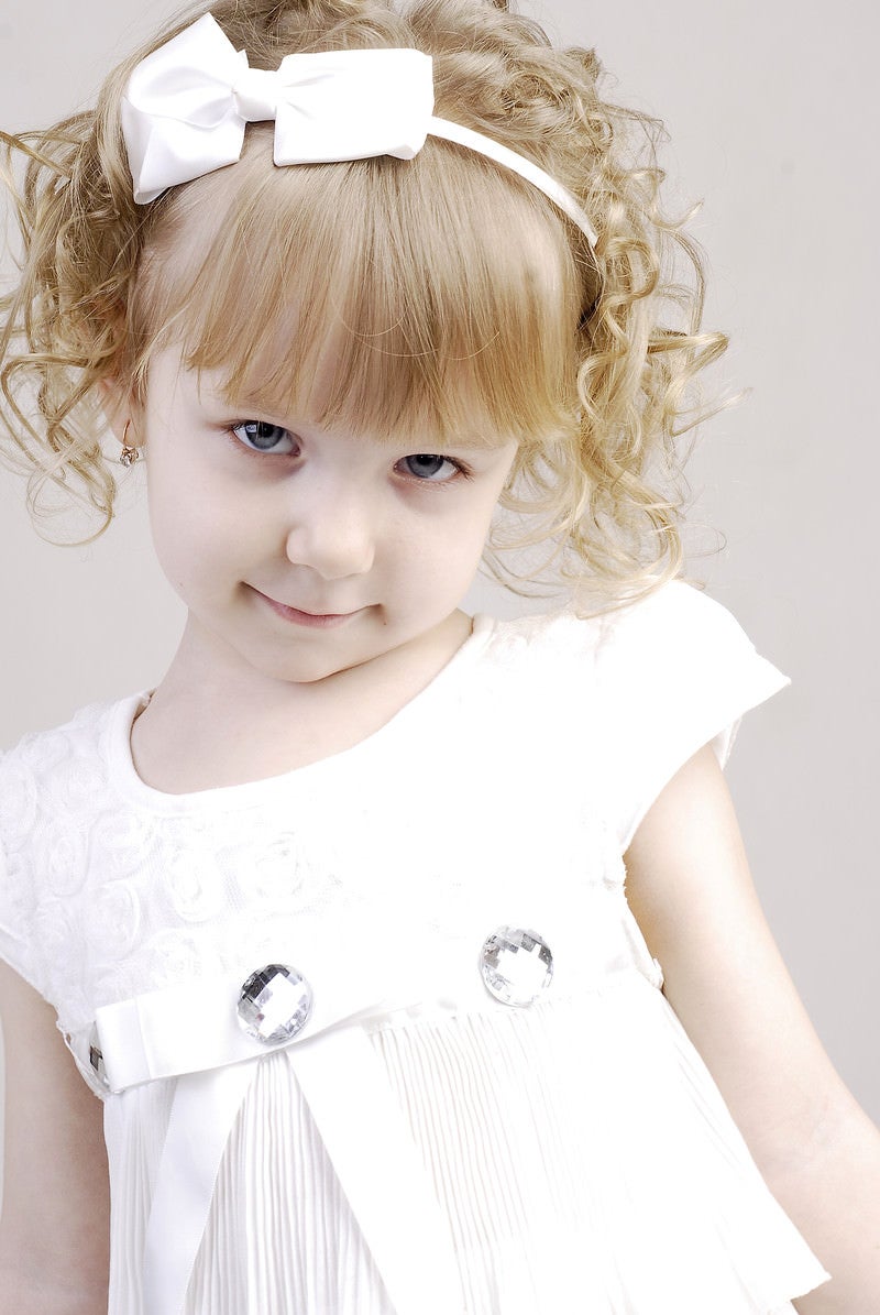 「白いお洋服を着たブロンドヘアの子供」の写真［モデル：モデルファクトリー］