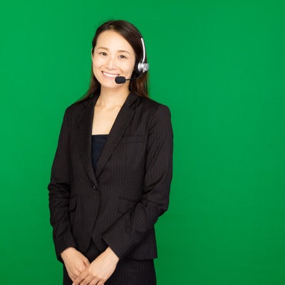 ヘッドセットを装着したコールセンターの女性（グリーンバック）の写真