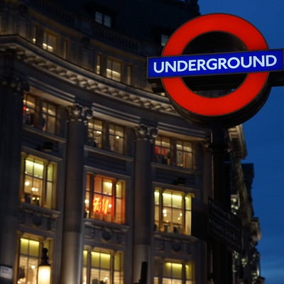 ロンドンの街並みと地下鉄の入口案内板の写真
