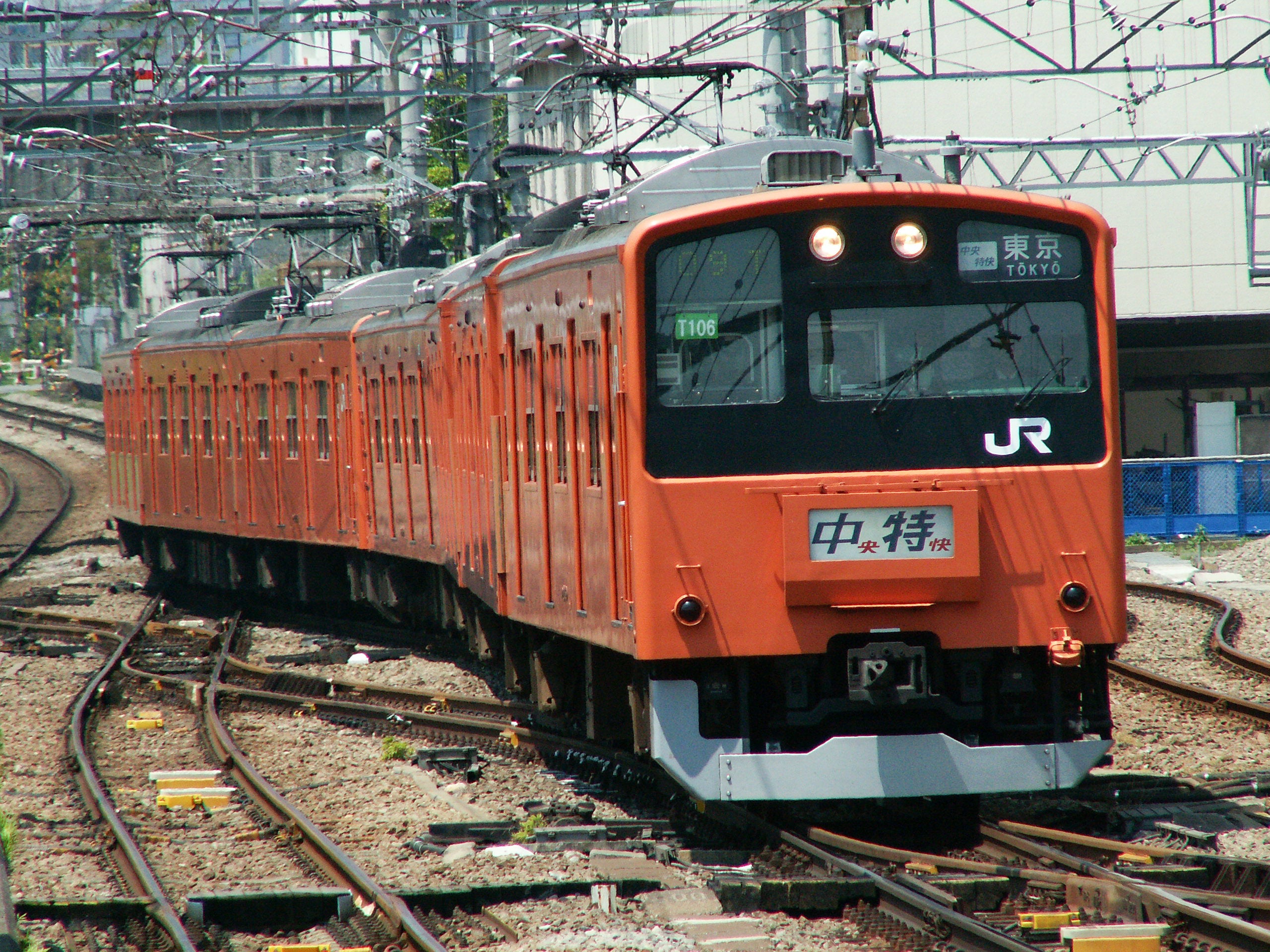 中央線201系の赤橙色電車が線路上に停車している風景の無料の写真素材