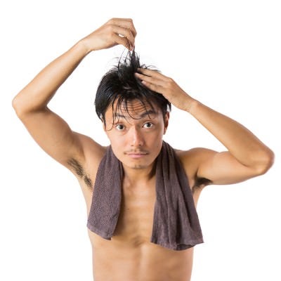 湯上がりに髪を気にする男性の写真