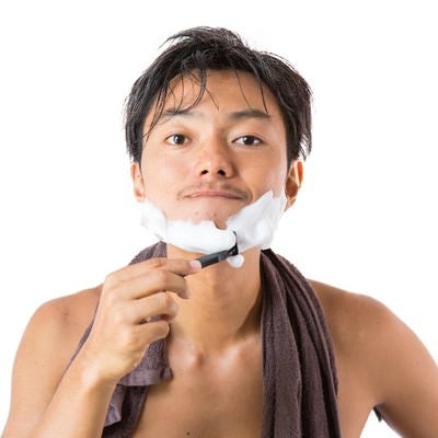 シェービングの泡でヒゲを剃る男性の写真