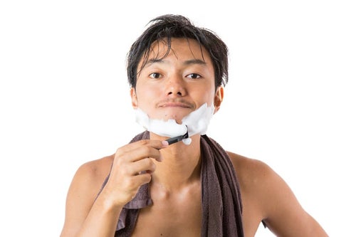 シェービングの泡でヒゲを剃る男性の写真