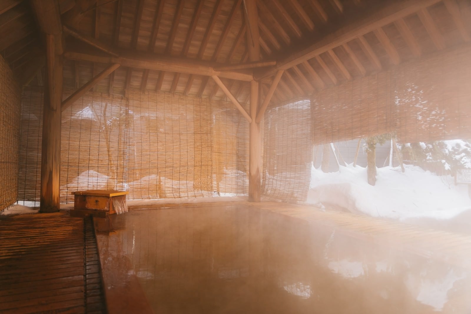 「溢れ出る温泉にざっぶーんと身を沈める平湯館の総檜露天風呂」の写真