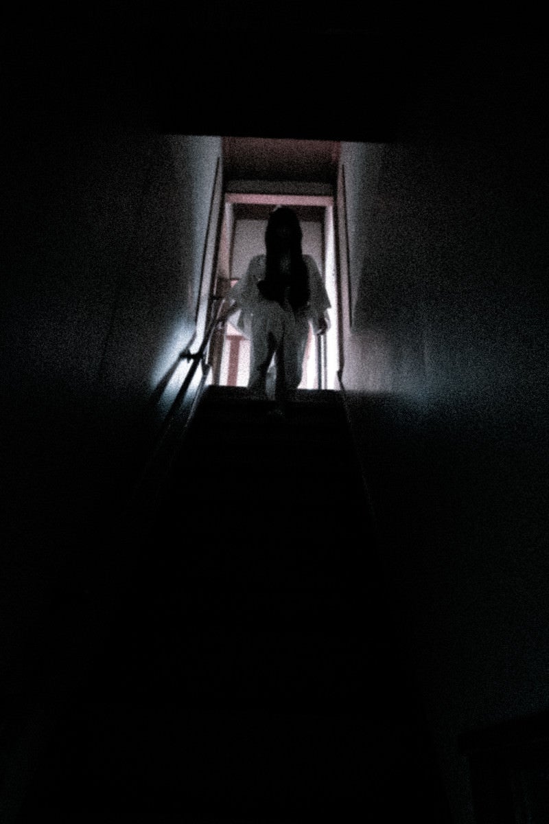 「階段から見下ろす不気味な女性」の写真