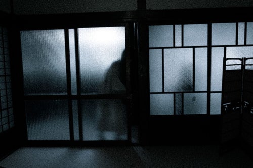 暗い部屋に入ろうとする人影の写真