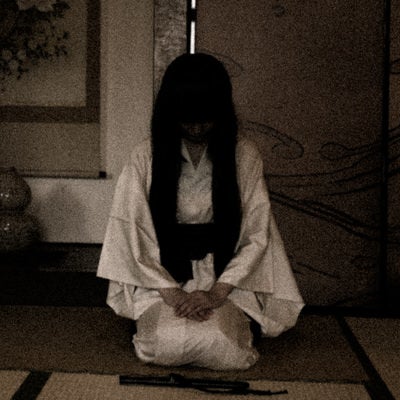 白装束の女性が和室で静かに佇むの写真