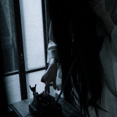 電話をかける髪の長い幽霊の写真