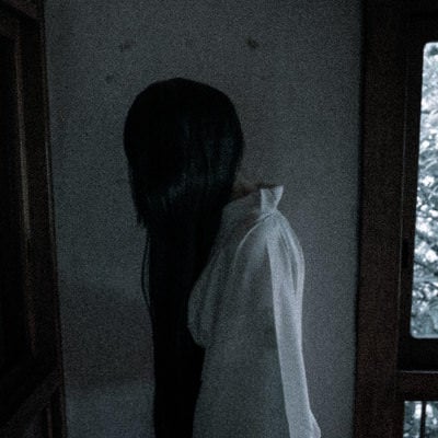 黒髪長髪の女性が部屋の中を徘徊しているの写真
