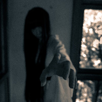 恨めしそうに手を伸ばす髪の長い幽霊の写真