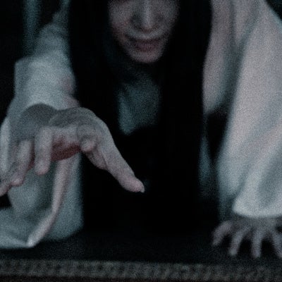 闇から手を伸ばす長髪の幽霊の写真