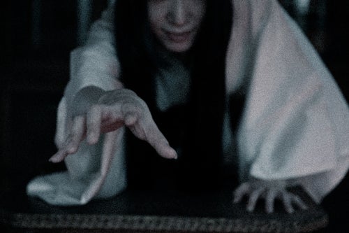 闇から手を伸ばす長髪の幽霊の写真