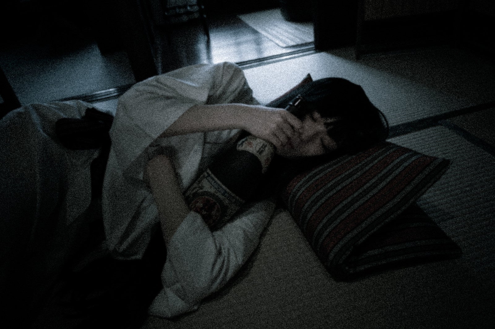 「折りたたんだ座布団を枕にして眠る泥酔女子」の写真［モデル：緋真煉］