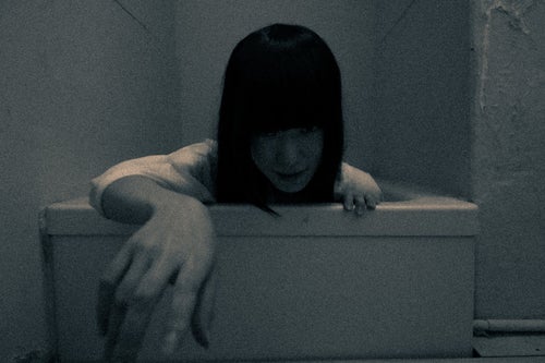 小さな風呂から這い出る女性の写真