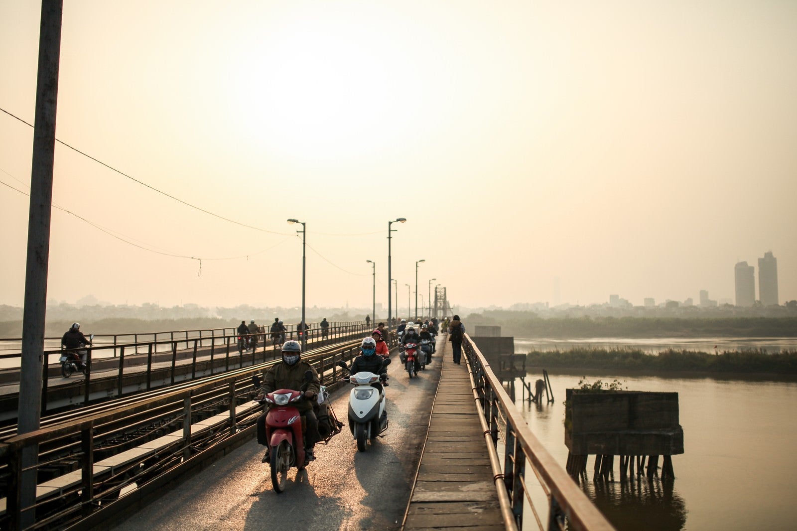 「ロンビエン橋を走行するバイクとベトナムの人々」の写真