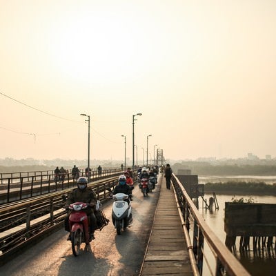 ロンビエン橋を走行するバイクとベトナムの人々の写真