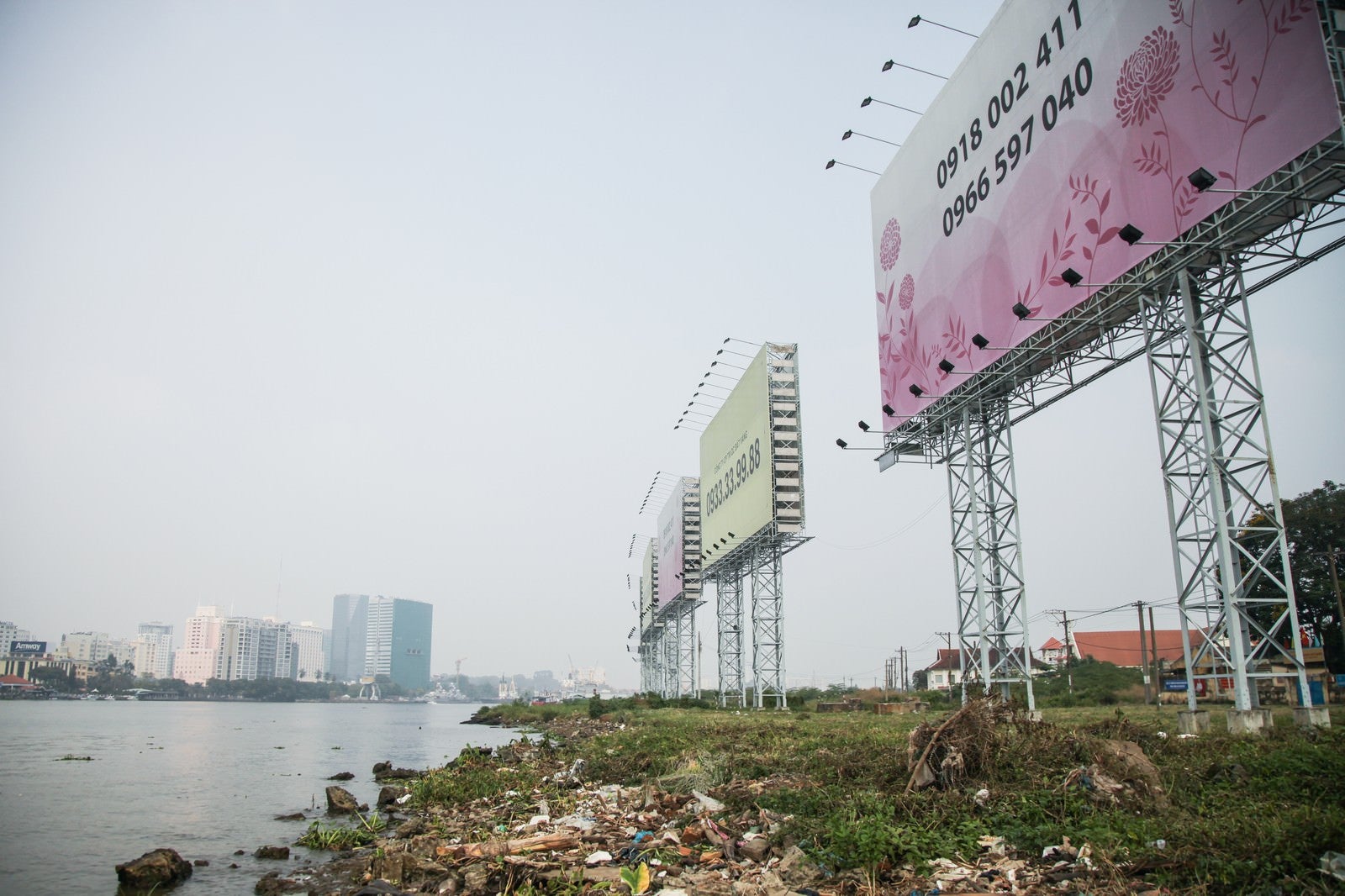 「ホーチミンの沿岸のゴミと広告看板」の写真
