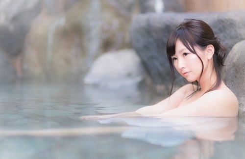 貸切状態の露天風呂を満喫する温泉好き女子の写真