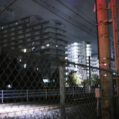 深夜の線路とフェンスの写真