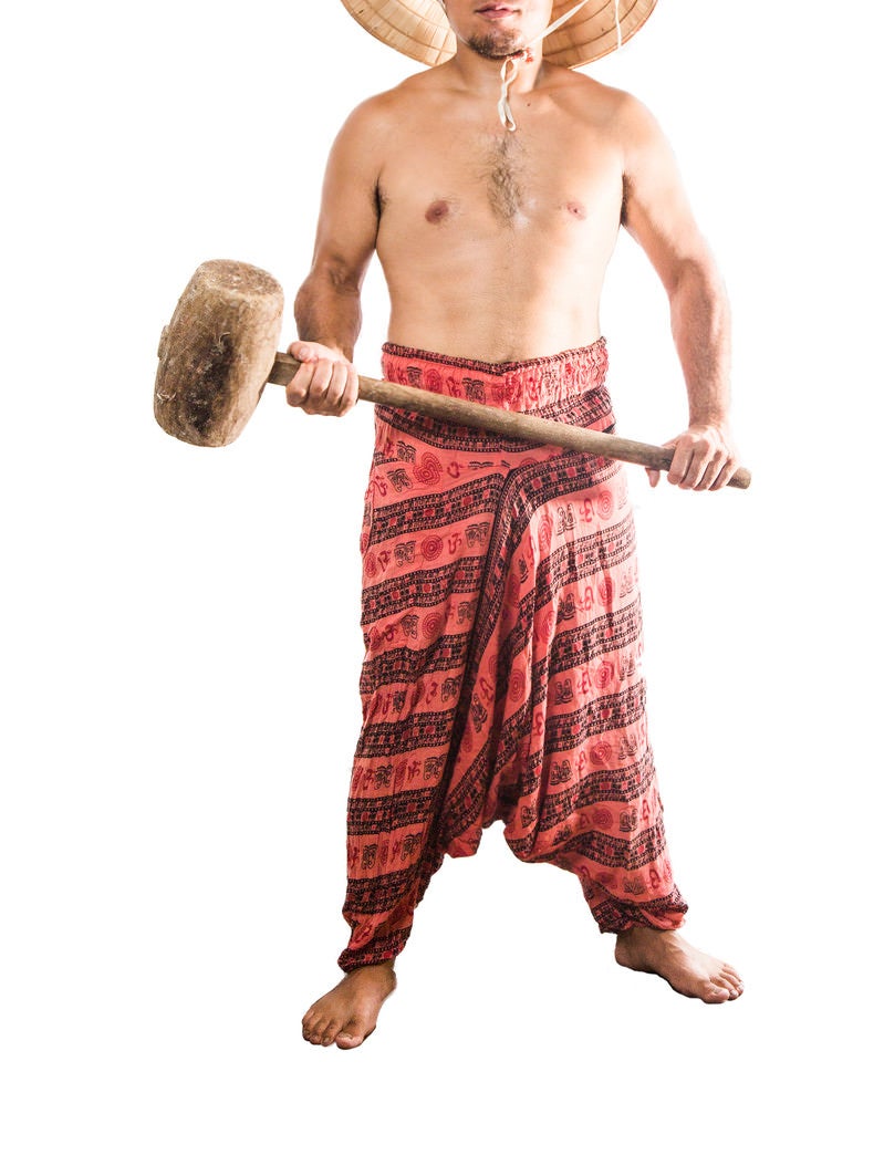 「木槌を持って前に立ちはだかる民族衣装の男性」の写真