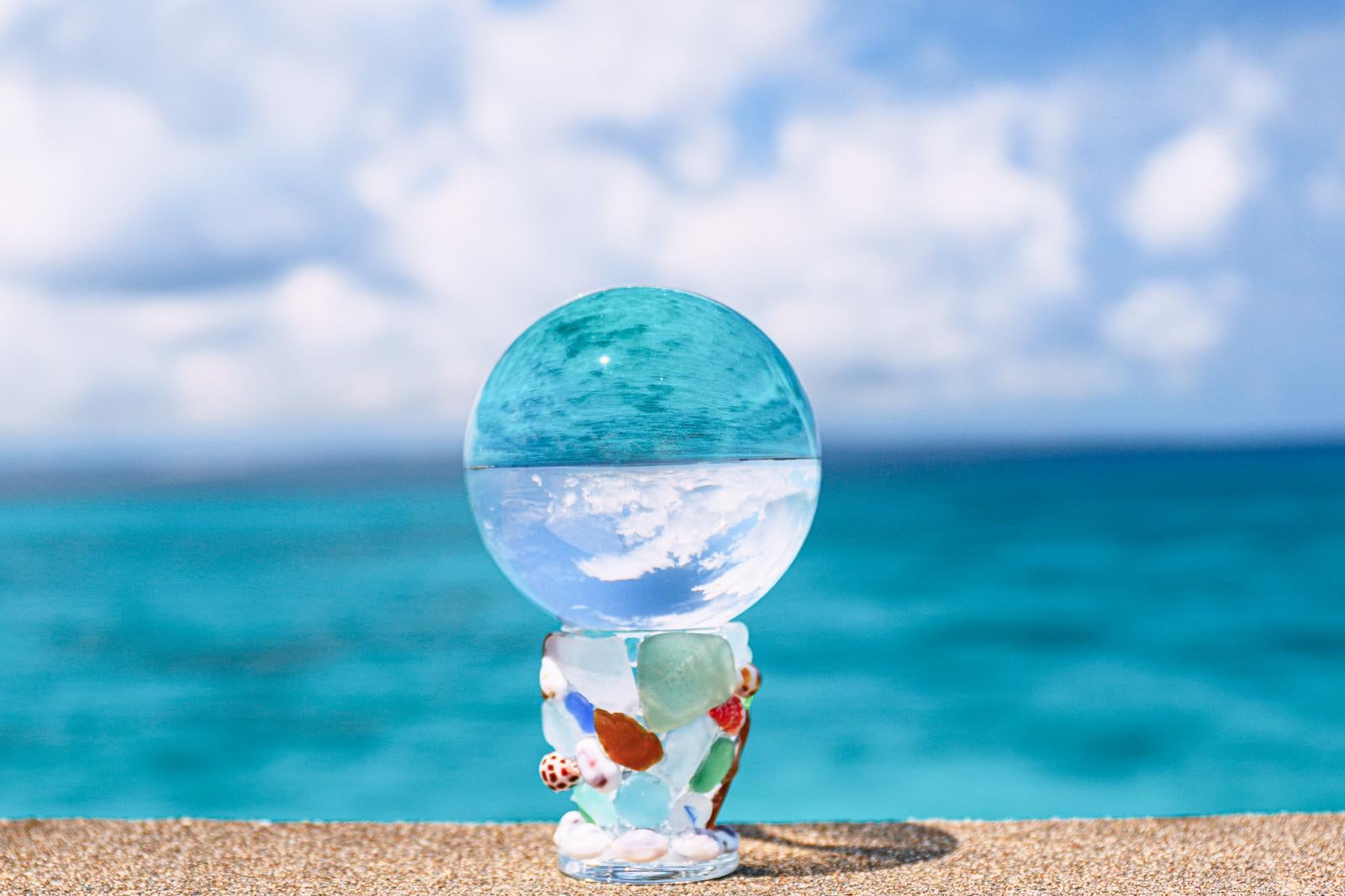 「ガラス玉に映り込む青い海」の写真