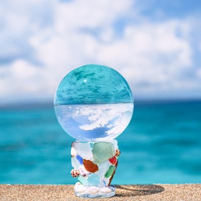 ガラス玉に映り込む青い海の写真