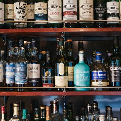 シングルモルトウイスキーやスコッチウイスキーなどのアイラモルト勢揃いの酒棚の写真