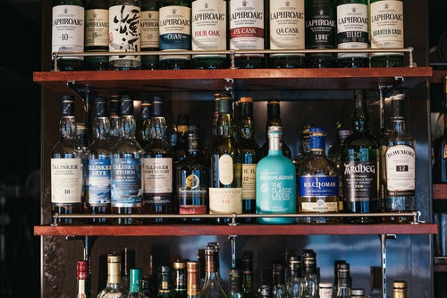 シングルモルトウイスキーやスコッチウイスキーなどのアイラモルト勢揃いの酒棚の写真