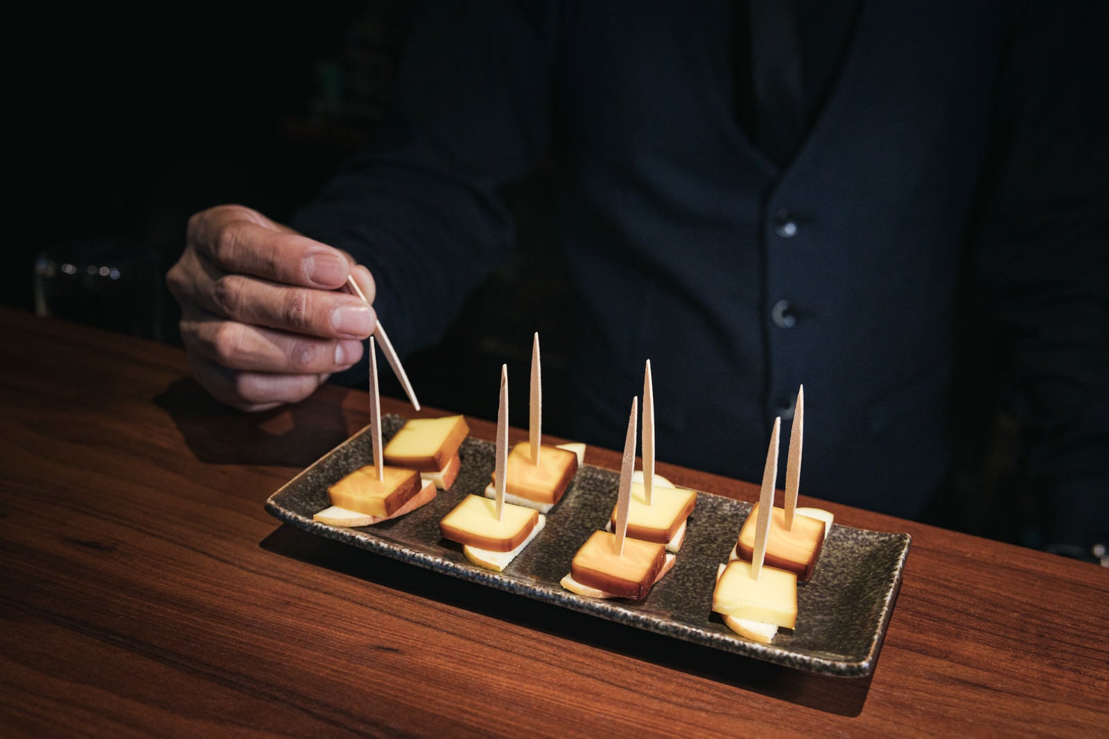 「一口サイズに盛り付けられたスモークチーズの燻製」の写真