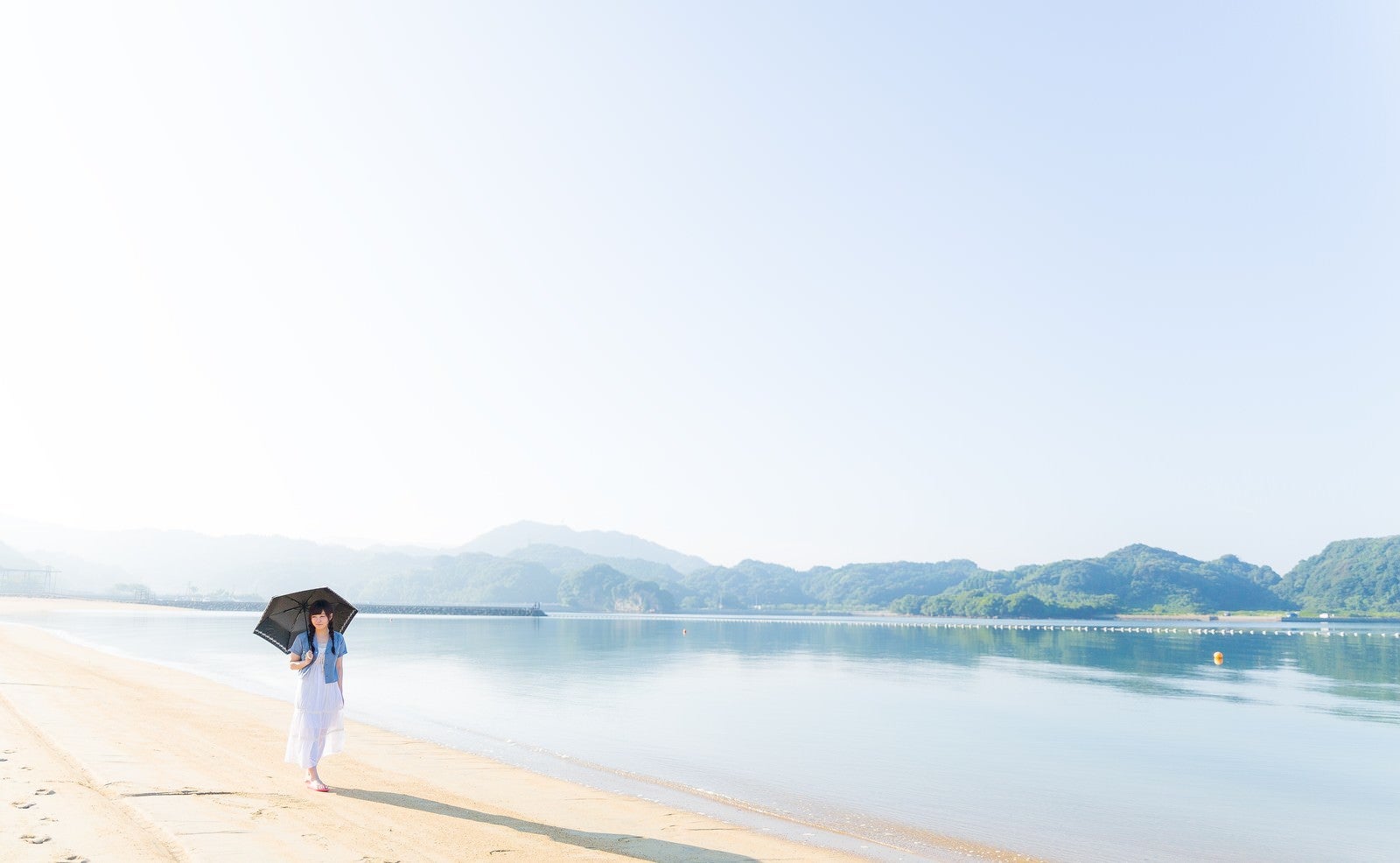 「穏やかなイマリンビーチを歩く日傘女子」の写真［モデル：河村友歌］