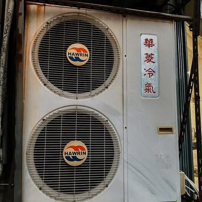 路地裏に佇む室外機の写真