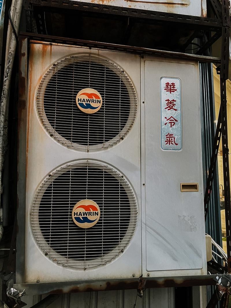 路地裏に佇む室外機の写真