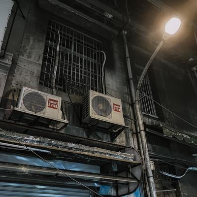 夜の路地裏に佇むエアコン室外機と街灯の灯りの素材