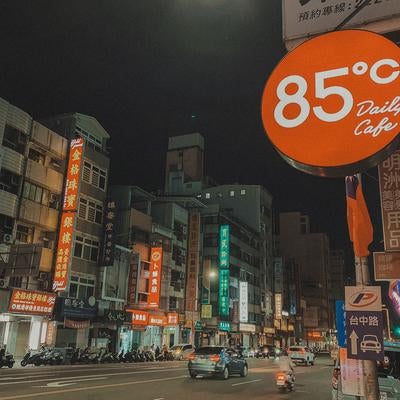 ネオンが輝く通りと85°Cカフェの看板の写真