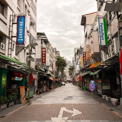 台湾の早朝の商店街をまっすぐに伸びる路地の写真