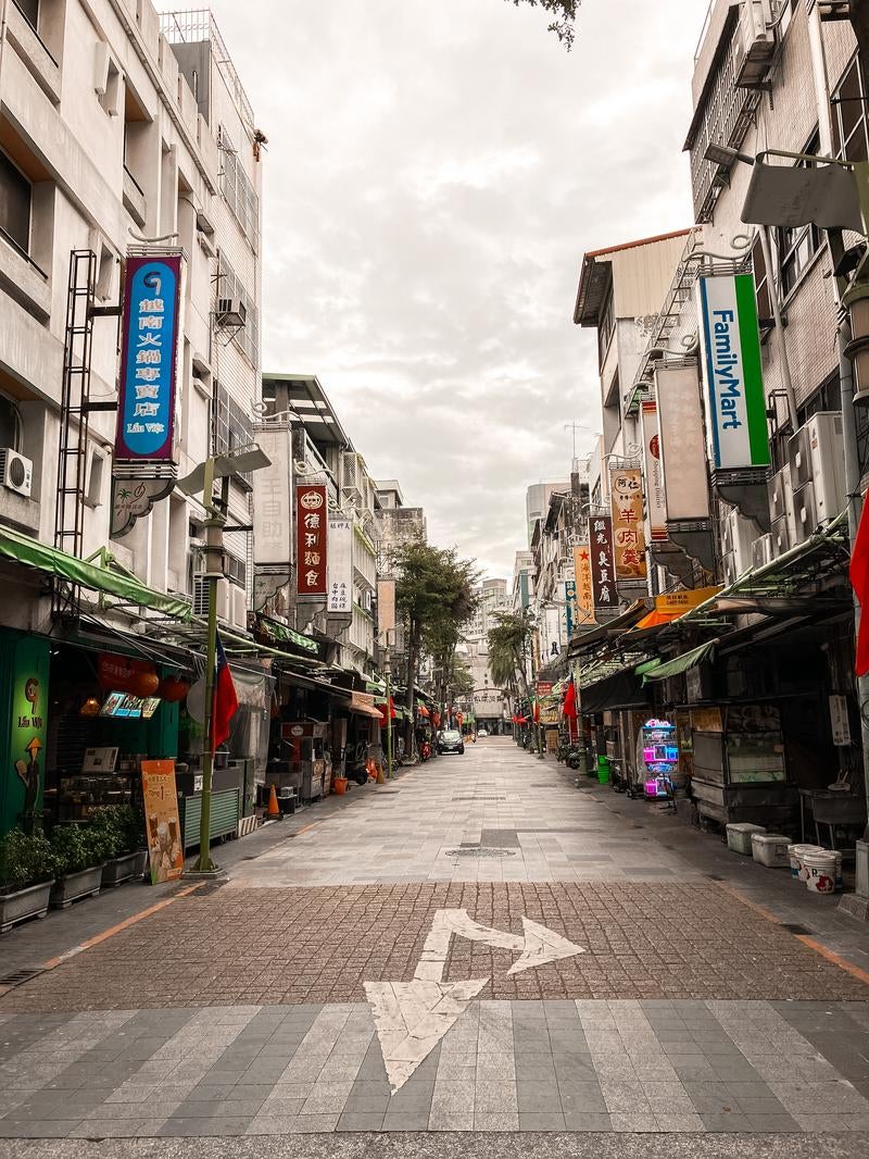 台湾の早朝の商店街をまっすぐに伸びる路地の写真