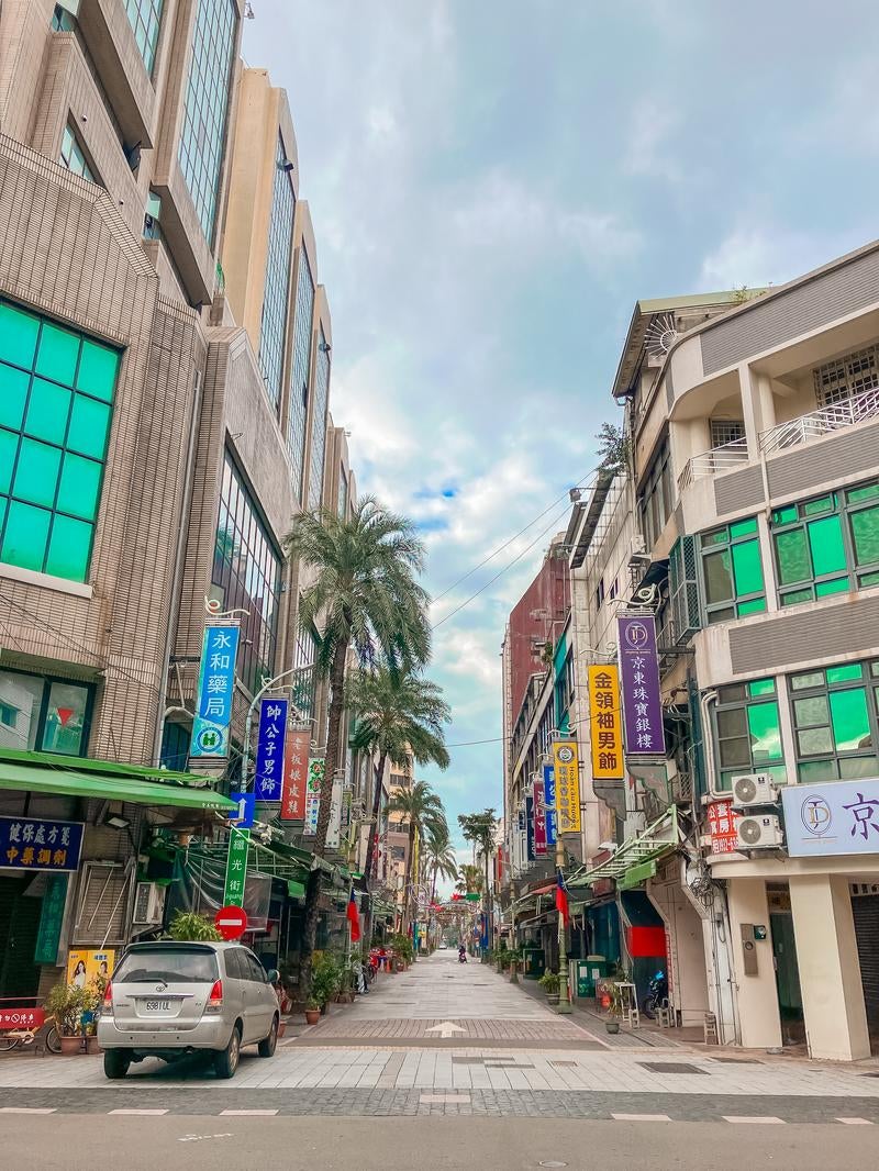 「ヤシの木が並ぶ台湾の商店街の入口」の写真