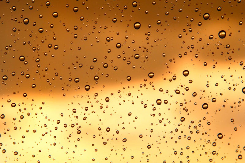 夕焼け空と窓の水滴の写真