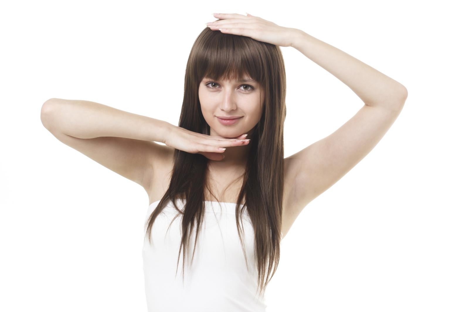 両手を頭上に上げてユニークなポーズをする黒髪ロングの若い女性［モデル：モデルリリース］