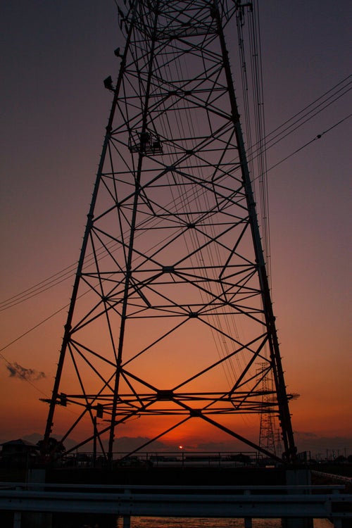 夕焼け空と鉄塔のシルエットの写真