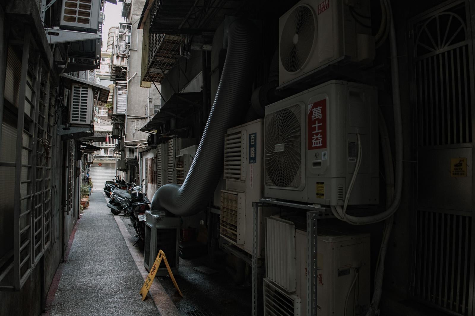 「台湾の狭い路地にびっしりと並ぶエアコン室外機」の写真