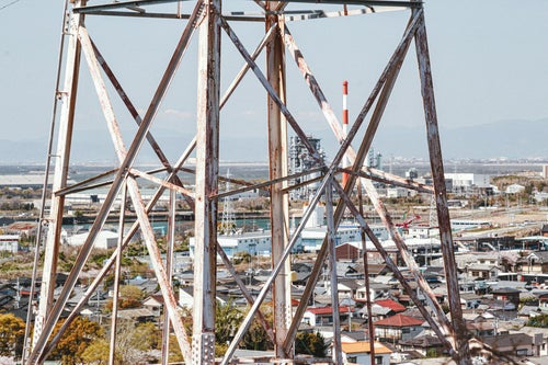錆びた鉄塔と工業地帯の写真