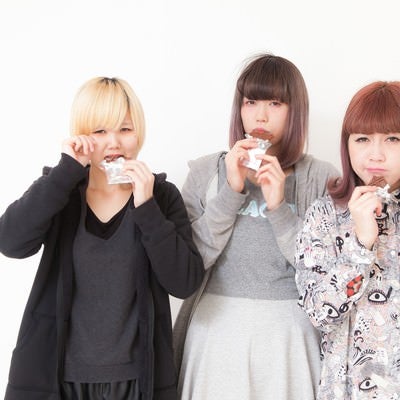 板チョコを噛みしめる女性三人組の写真