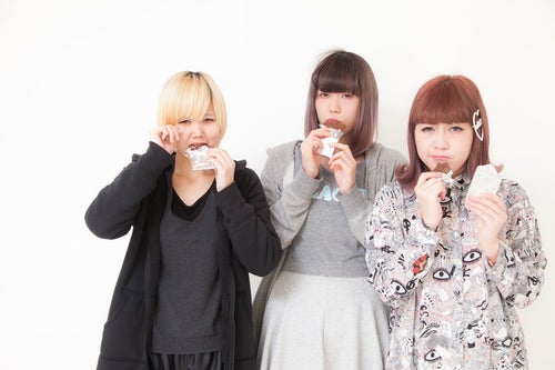 板チョコを噛みしめる女性三人組の写真