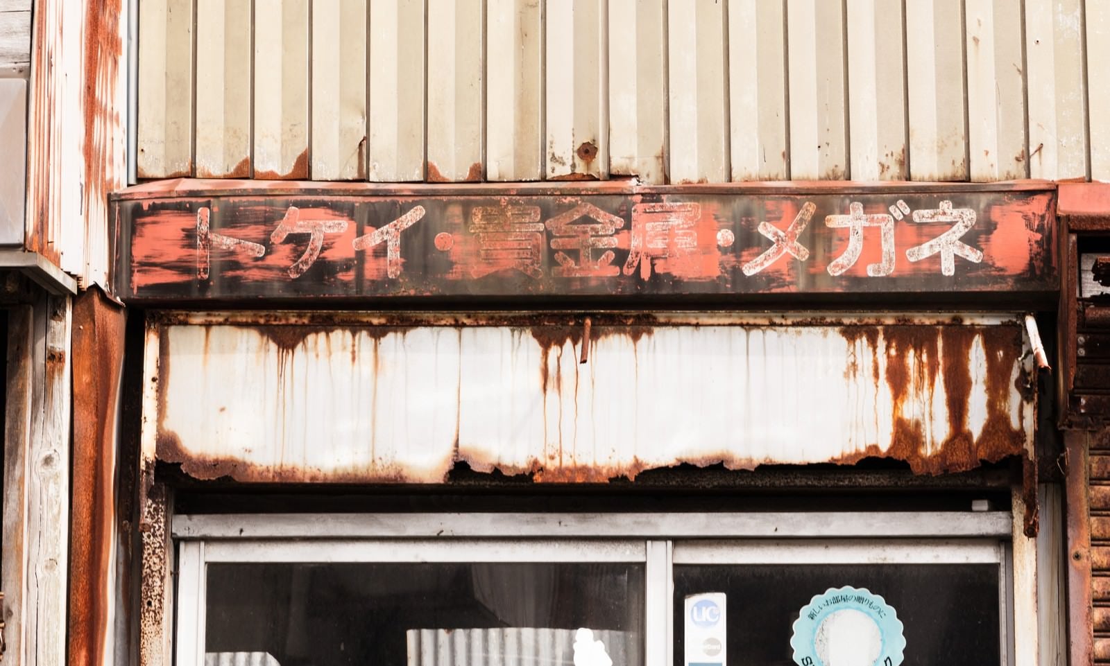 「トケイ･貴金属･メガネの錆びた看板」の写真
